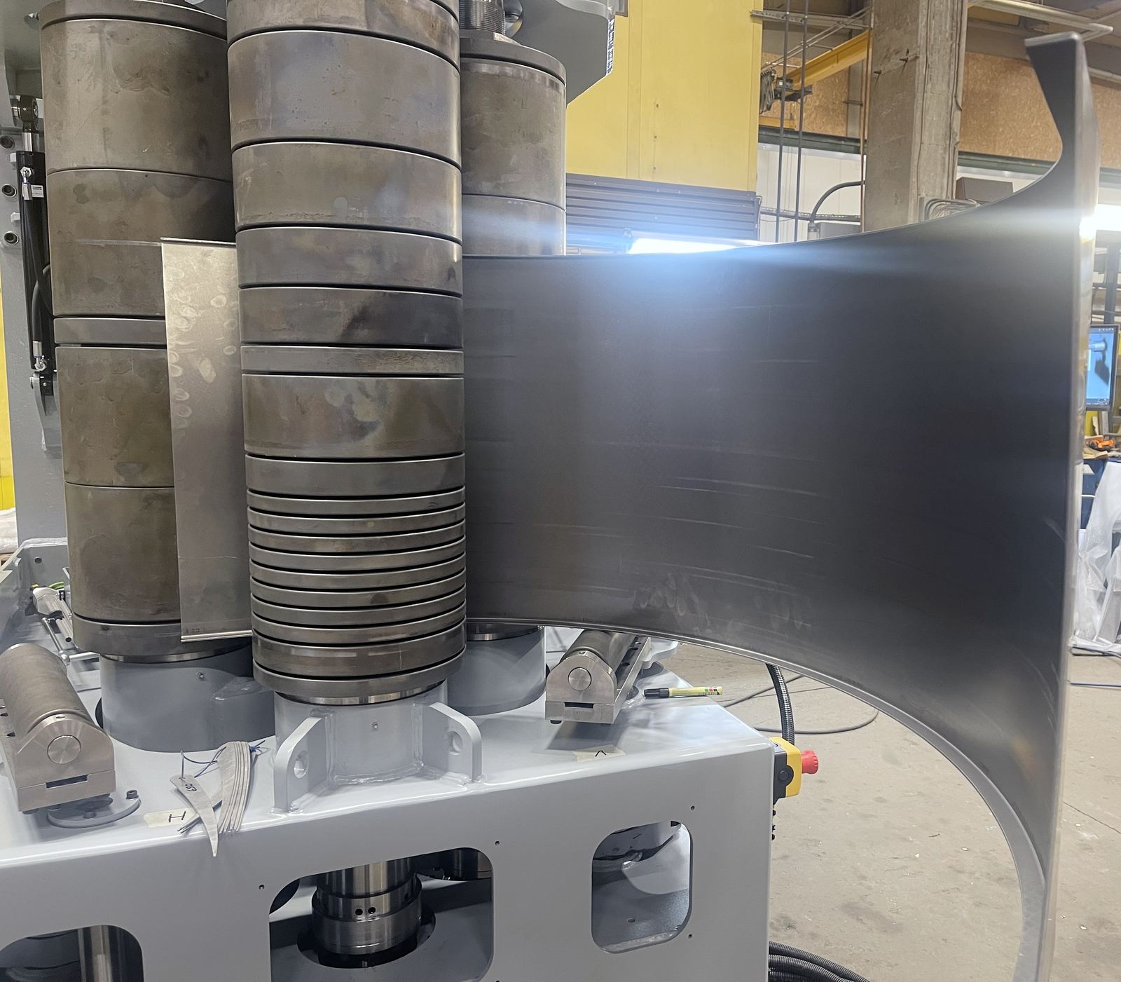 SweBend SB3-105 CNC section bending machine with flanged plate loaded between profiled rolls and hydraulic guide rolls