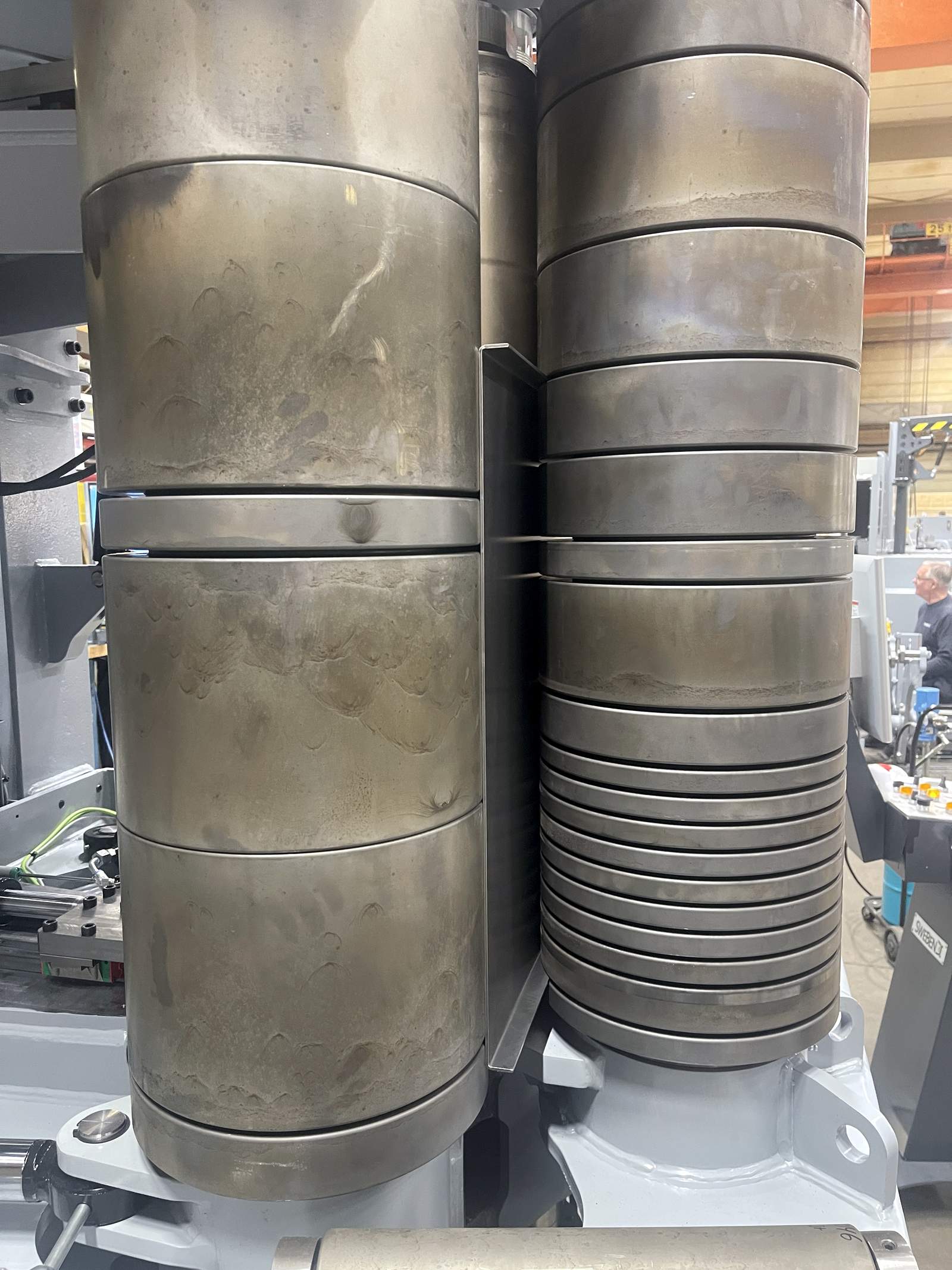 Close-up of profiled forming rolls on the SweBend SB3-105 CNC showing segmented roll geometry for flanged plate bending