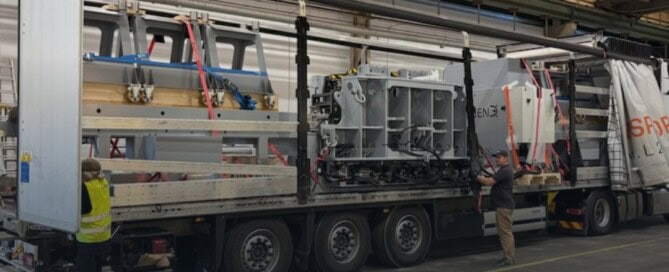 SweBend VSB3-70 CNC section bending machine strapped down on a flatbed trailer before shipping to GVB Infra